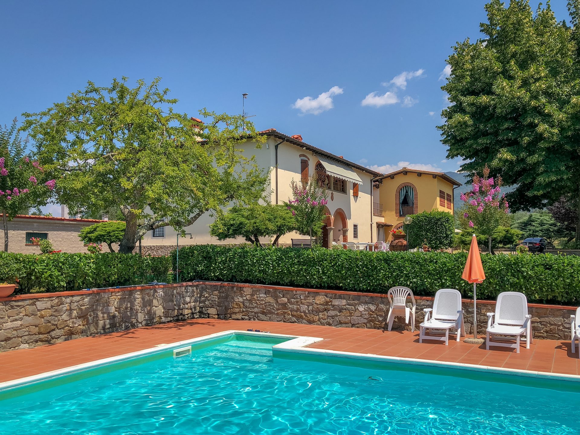 La piscina dell'agriturismo con il casale sullo sfondo