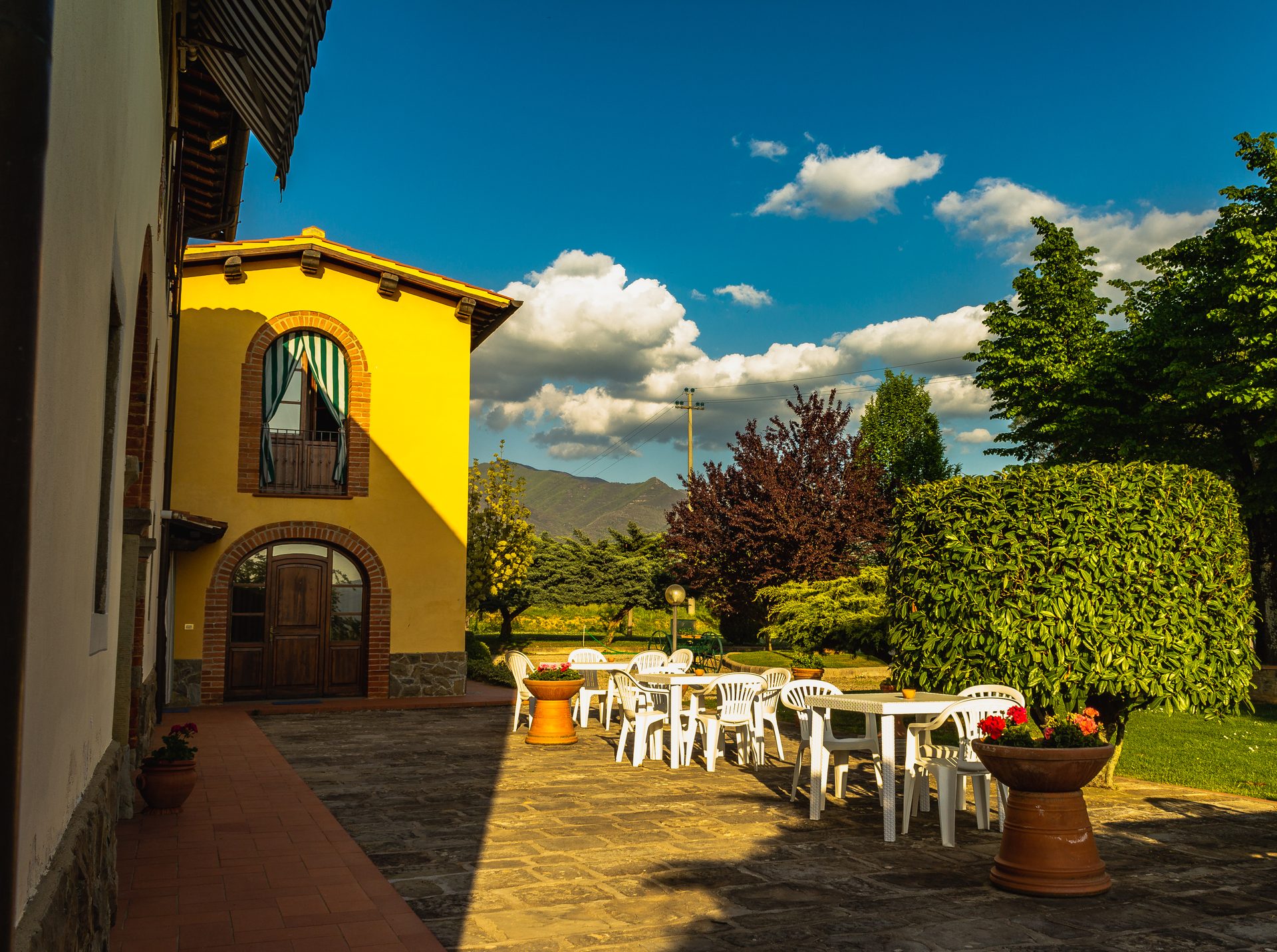 La facciata gialla del casale e il terrazzo con i tavoli
