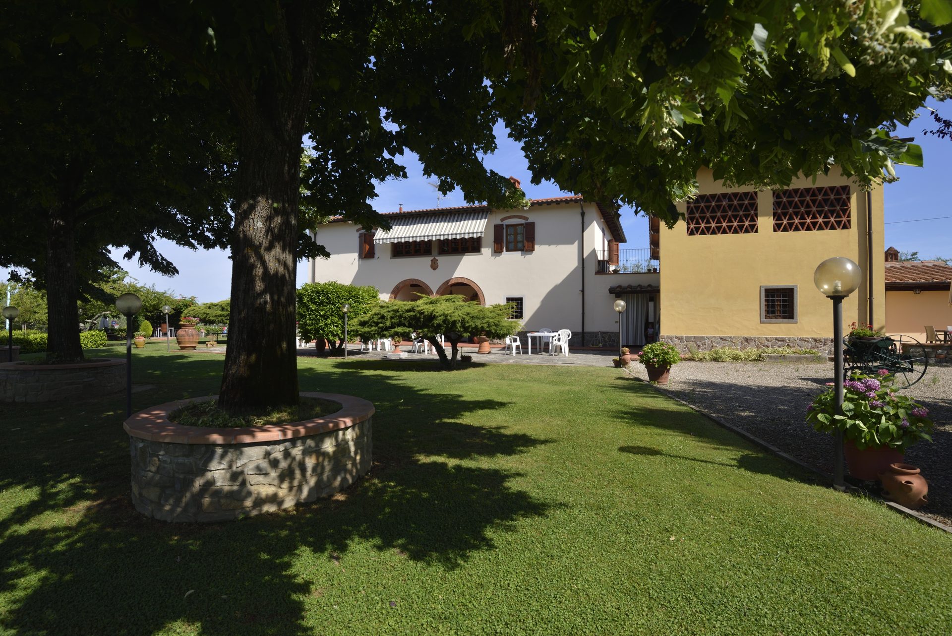 Il parco con il grande albero davanti al casale toscano